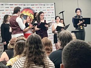 Emily's photo shows choral singers with the back of some audience members in the foreground